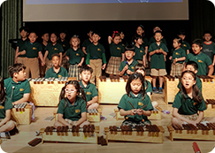 APIS elementary school students playing Orff instruments in music program